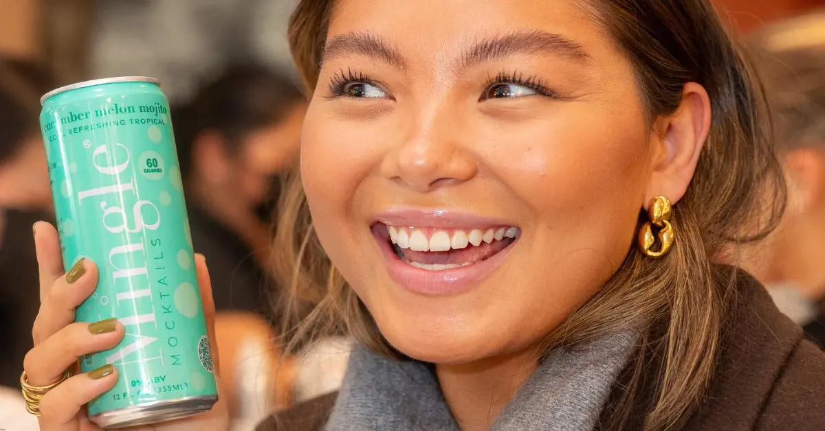 Non-alcoholic mojito can of Mingle Mocktails held by a smiling woman in a vibrant setting