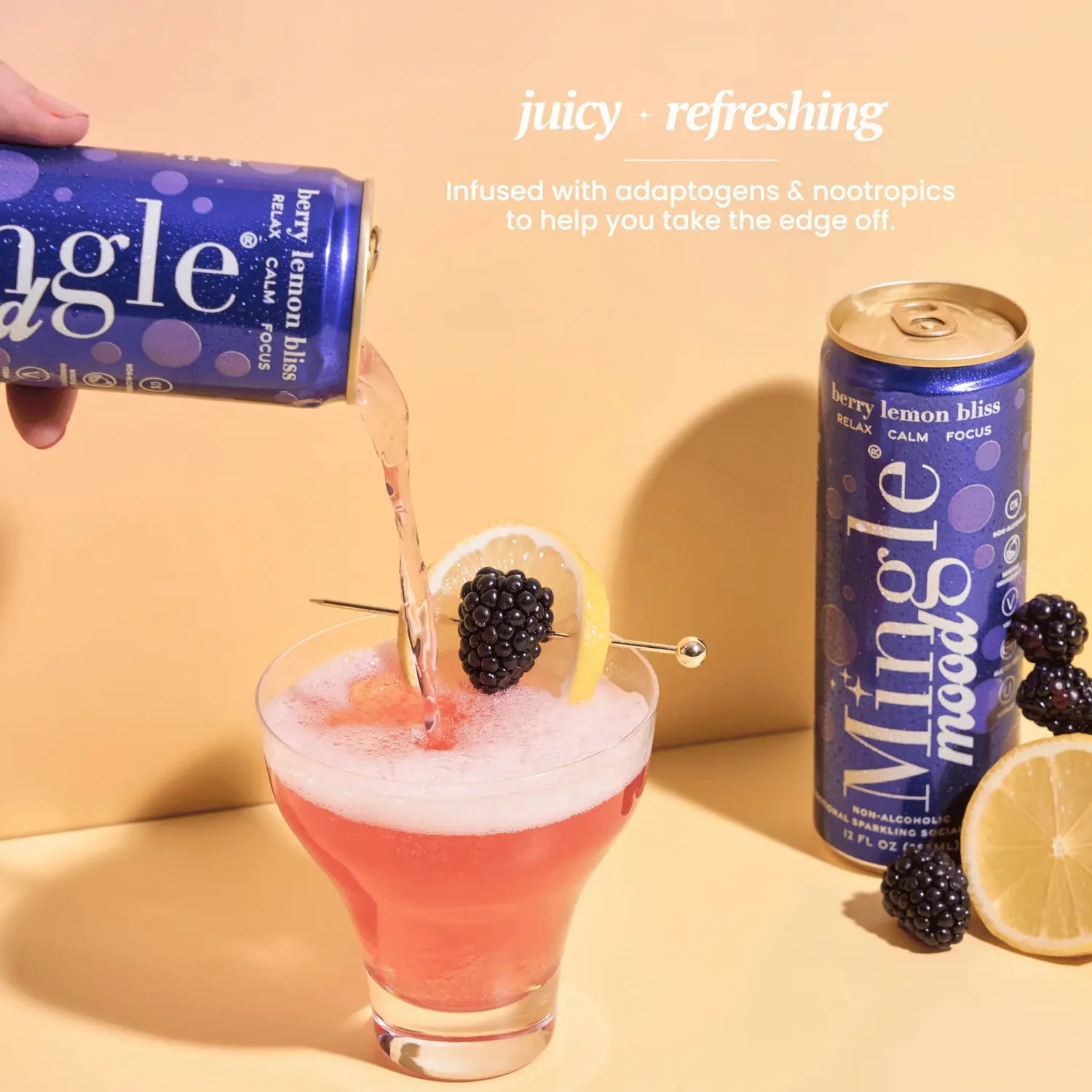 Mingle Mood Berry Lemon Bliss being poured from a navy blue can into a cocktail glass garnished with blackberry and lemon.