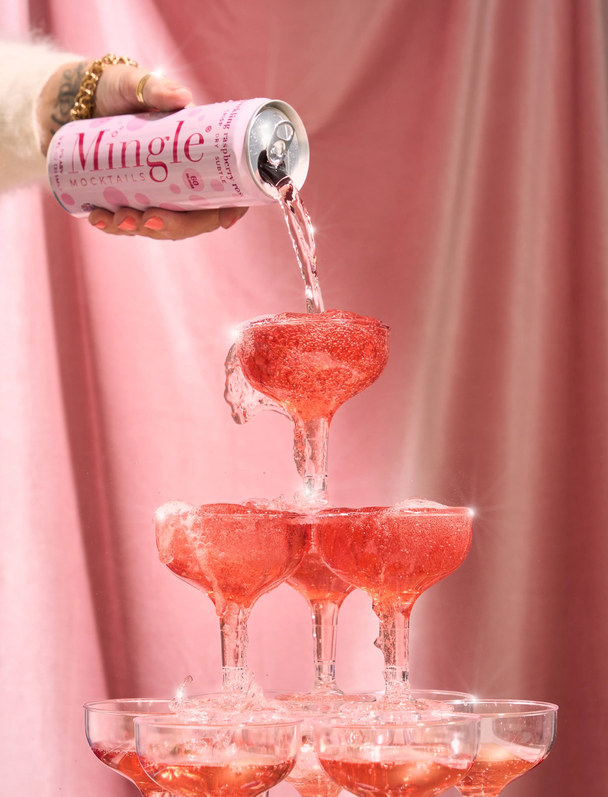 Mingle Mocktails Sparkling Raspberry Rose can pouring over a tower of coup glasses