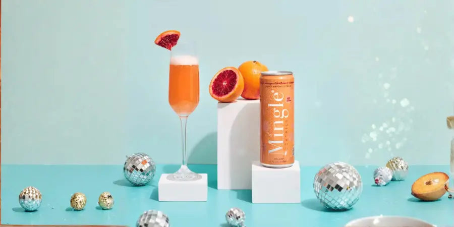 Party mocktail served in champagne flute with grapefruit garnish next to sparkling can
