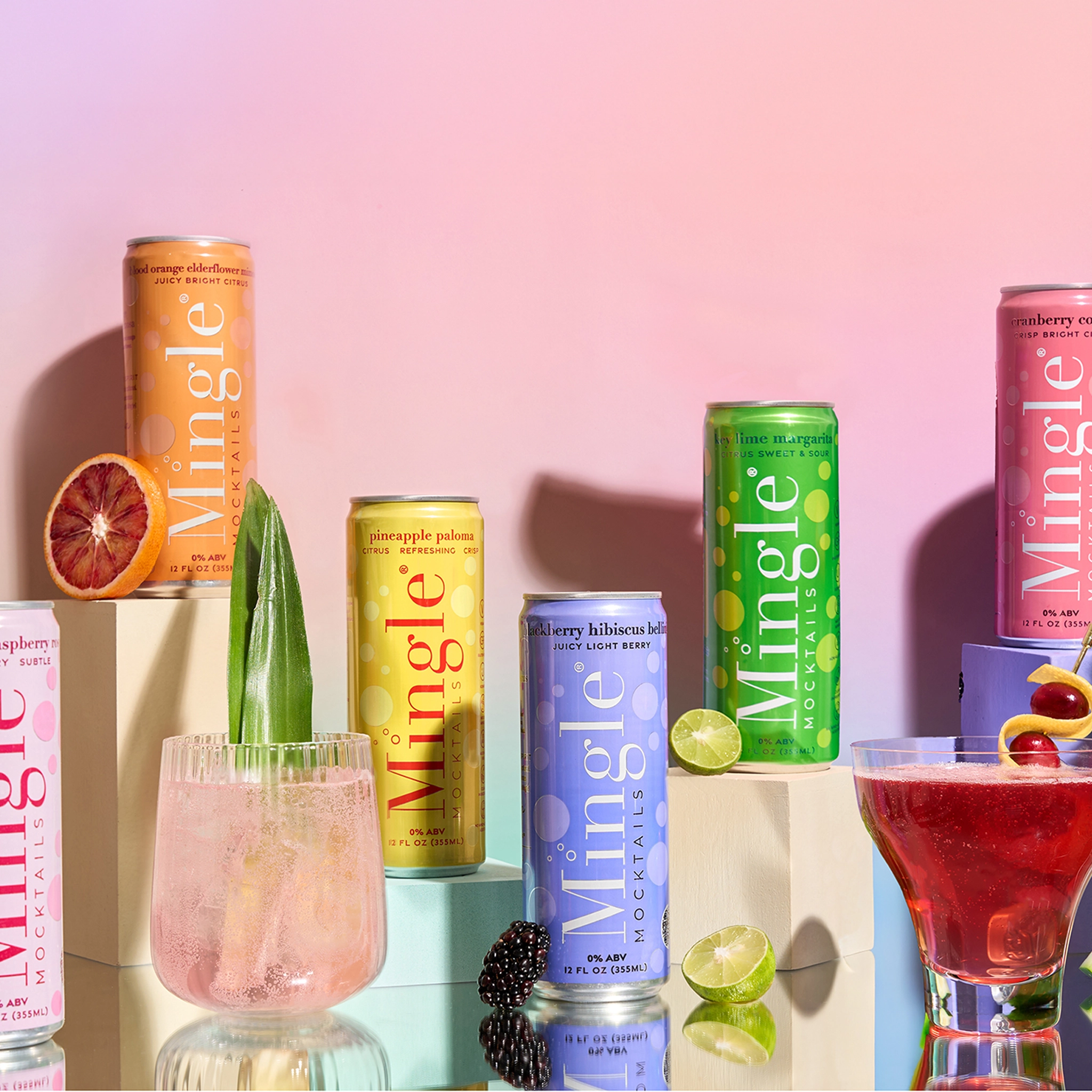 All six Mingle Mocktails cans on pedestals with fresh fruit garnishes and cocktail glasses on a pink gradient background.