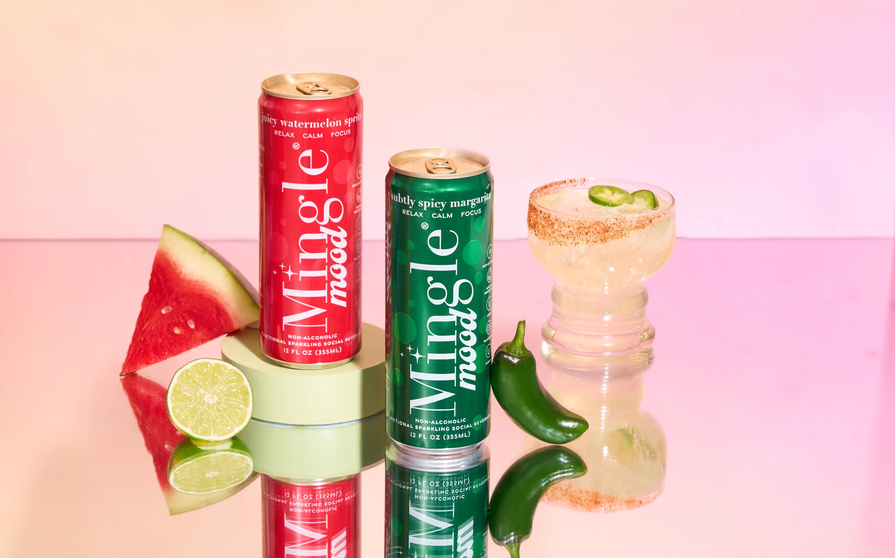 Mingle Mood watermelon spritz and spicy margarita cans beside a chili-rimmed mocktail glass.