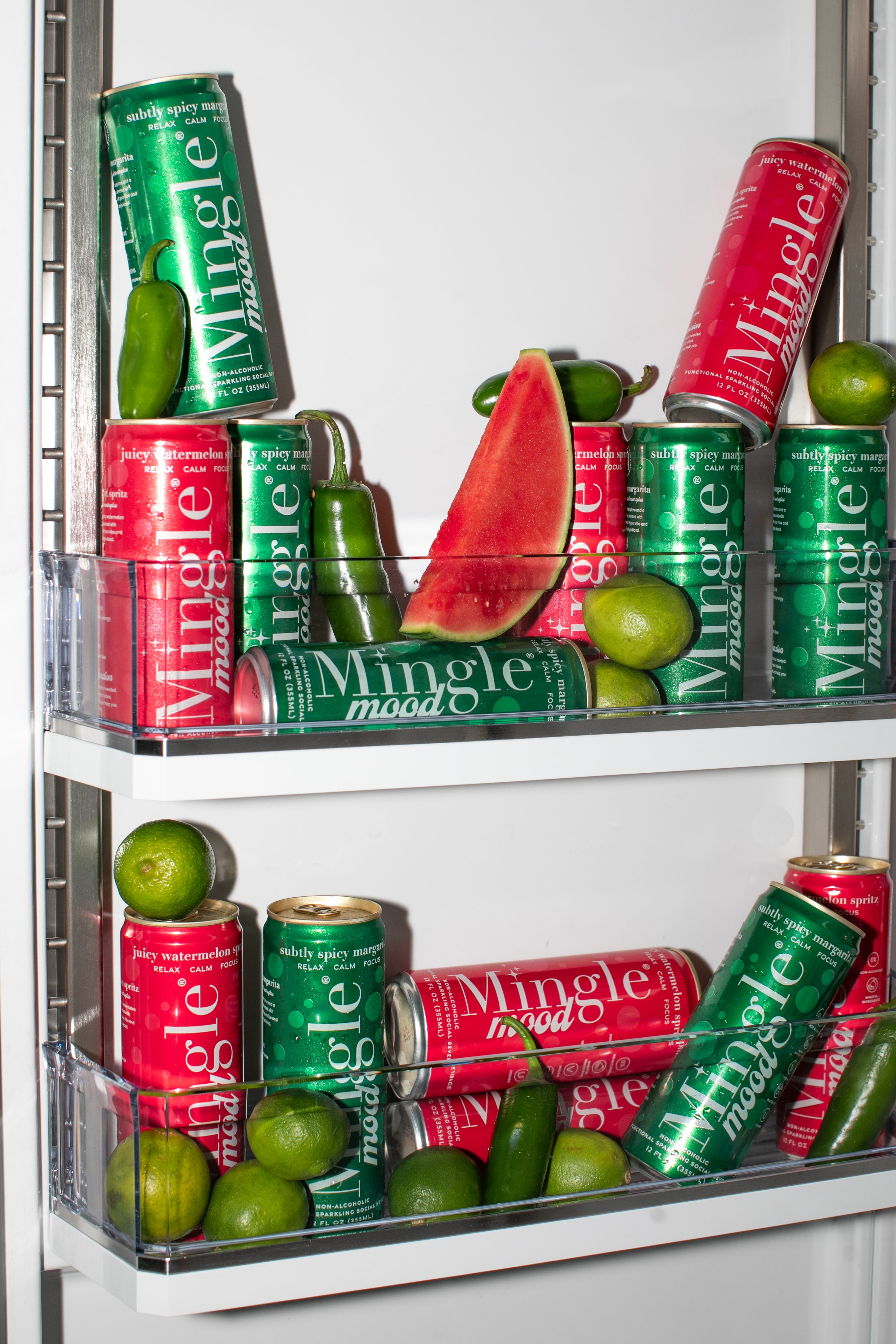 Mingle Mood spicy margarita and watermelon spritz cans chilling in fridge with limes and jalapeños.