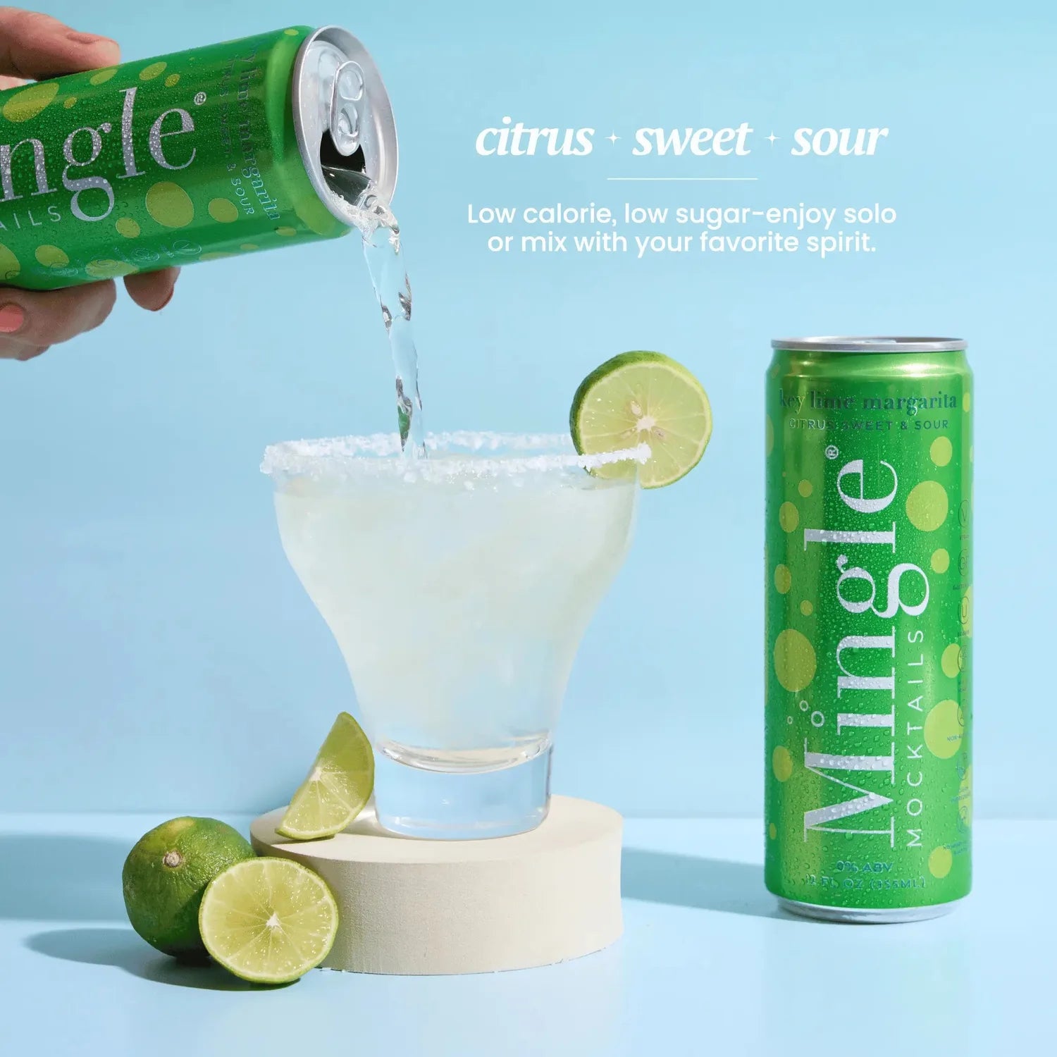 Mingle Mocktails Key Lime Margarita being poured from a green can into a salt-rimmed glass with fresh lime garnish.
